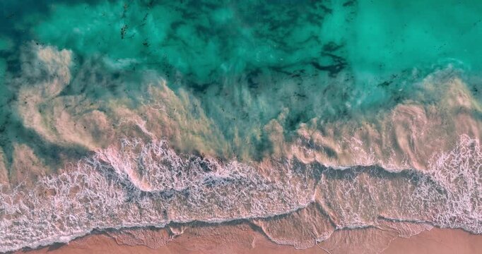 Aerial View of Turquoise Ocean Waves Washing Over Sandy Beach Shoreline Concept for Summer Tropical Vacation 