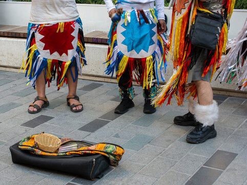 Close-up waist down view of three musicians in traditional costumes busking in a city street, Turkey