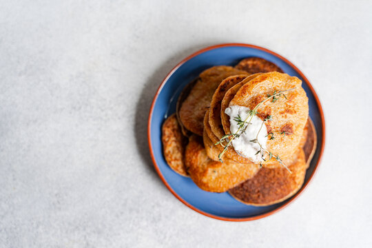 Overhead view of a stack of Potato pancakes (draniki) with natural yogurt and fresh thyme