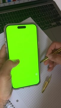 Smartphone mockup with green screen.Free advertising template.Woman working and scrolling her phone cel.Perfect for agencies and content creators 
