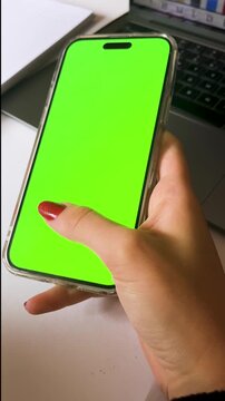 4k video of a woman working with her cellphone. Professional smartphone mockup with green screen ready for advertising projects.Ideal for on line working ads.