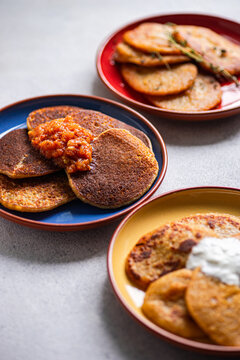 Close-up of three different coloured plates with Potato pancakes (draniki) and various sauces