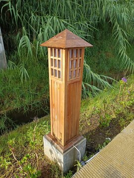 Tempat lentera di taman berbentuk rumah kecil dari kayu 