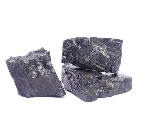 A close-up photo of coal against a white background. Coal is an organic sedimentary rock composed primarily of carbon and is combustible.