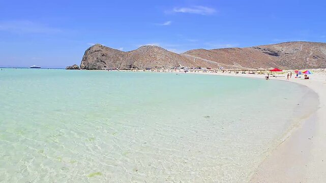 La Paz, Baja California Sur, M&eacute;xico. Playa Balandra: una soleada ma&ntilde;ana de vacaciones de verano con aguas cristalinas y arena blanca, bajo un cielo azul y con monta&ntilde;as al fondo.
