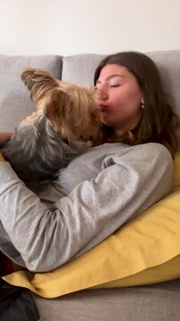 Tender moments between owner and dog at home. Scene of affection and emotional bond between human and pet.Vertical 4k video.Cozy and warm home atmosphere.