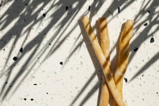  miswak chewing sticks on a light terrazzo surface in bright sunlight.Traditional natural toothbrush used for oral hygiene, dental care and sustainable zero waste lifestyle.