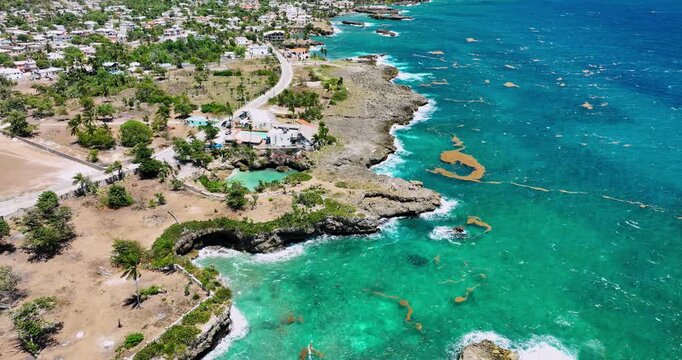 Ocean Waves Crashing Against Rocky Cliffs Along a Coastal Beach, Caribbean sea shoreline, Boca De Yuma, Dominican Republic aerial landscape
