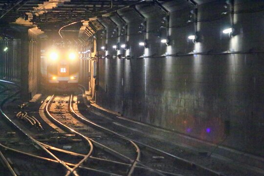 トンネルの闇を切り裂くヘッドライトと特急列車