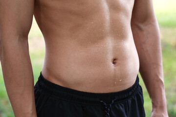 Naklejka premium Athletic man with sweat on his body outdoors, closeup
