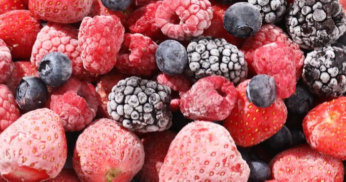 Mix of frozen berries as background, closeup. Camera moving