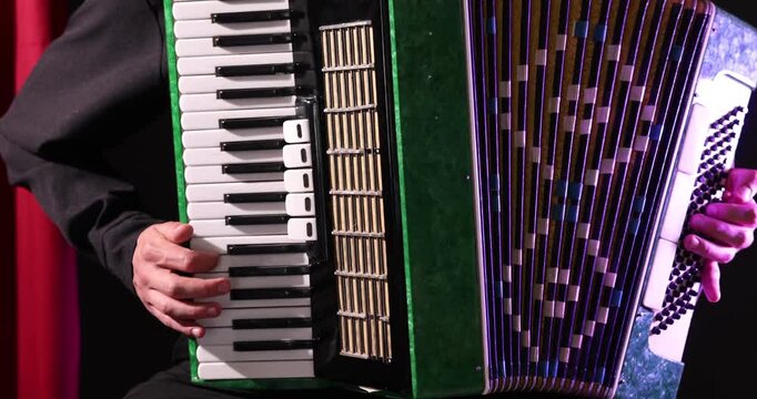 Man playing piano accordion on stage, closeup