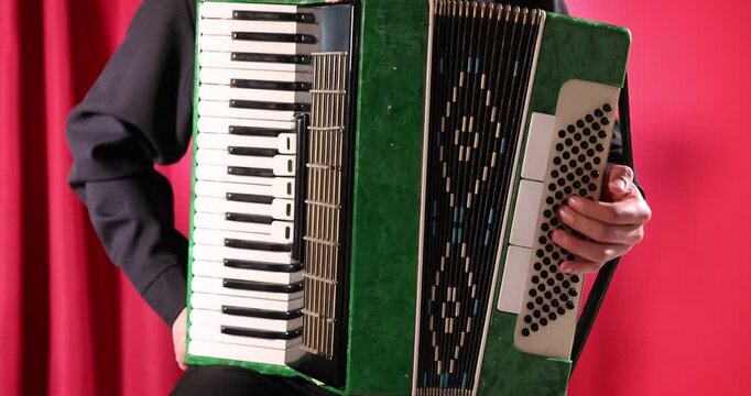 Man playing piano accordion on stage, closeup