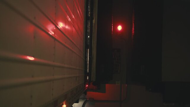 Truck backing up to loading dock at night