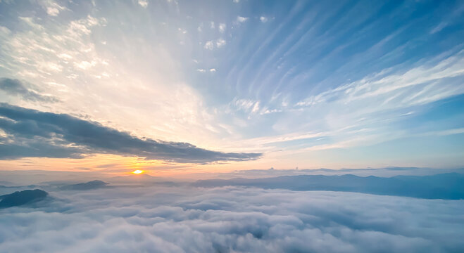 Beautiful sunrise landscape background with dense sea of fog over mountains and dramatic colorful clouds sky for panoramic travel design