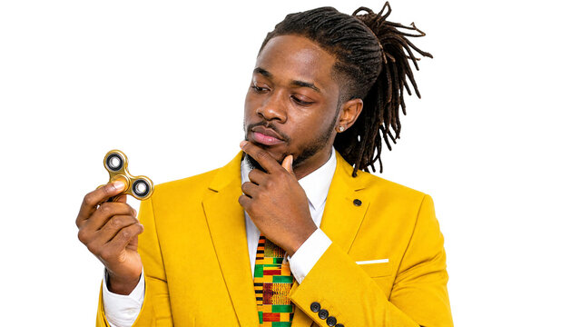 Thoughtful Stylish Black Man in Yellow Suit Holding Gold Fidget Spinner Isolated