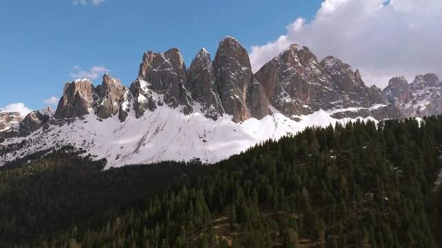Odle peaks in the Puez-Geisler region, Dolomites, South Tyrol. Forest beneath snow capped mountains