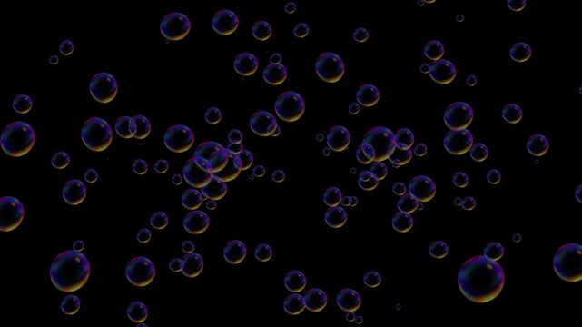 Floating soap bubbles rising against dark background for abstract visual background.