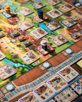Portrait close up product photography of Great Western Trail components showing building tokens worker tokens and train pieces designed by Alexander Pfister and Chris Quilliams