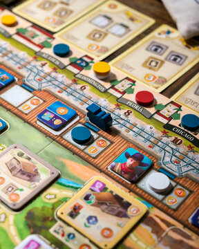 Portrait close up product photography of Great Western Trail components showing building tokens worker tokens and train pieces designed by Alexander Pfister and Chris Quilliams
