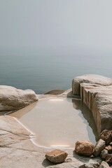Obraz premium Minimalist stone pool with glowing water overlooking a hazy sea for luxury wellness and premium spa branding