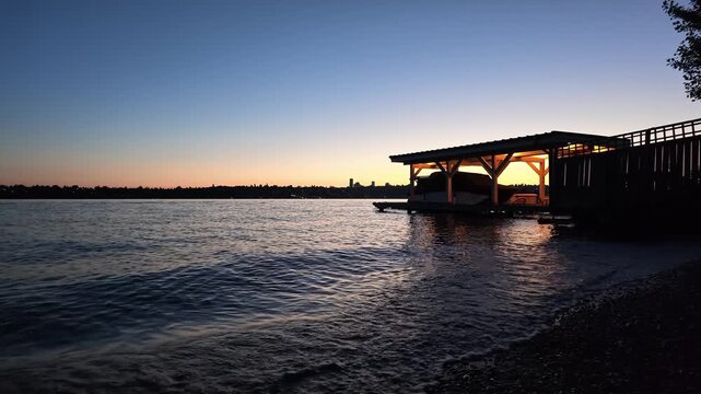 Boat dock with city skyline silhouette at twilight