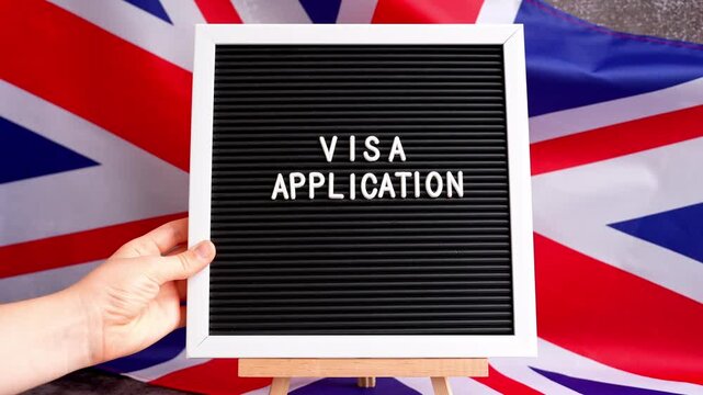 Letter board text VISA APPLICATION National symbol of Great Britain. British wave the UK silky flag background. Concept of temporary work permit employment migration