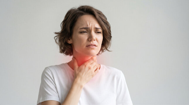 Young woman touching her neck feeling pain, suffering from sore throat, thyroid problem or laryngitis, healthcare and medicine concept