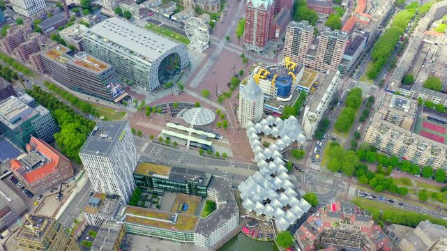 Rotterdam, Netherlands. Drone footage of the Cube Houses and Markthal, showcasing the tilted cubic residences designed by Piet Blom and the horseshoe-shaped market hall under an overcast sky.. Drone 