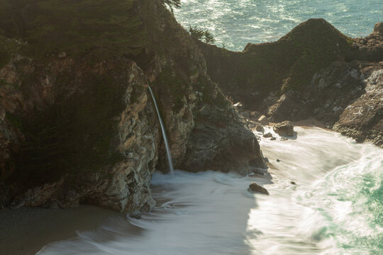 McWay Falls cascades onto a beach in Julia Pfeiffer Burns State Park, Big Sur, California, USA. The iconic waterfall flows directly into the Pacific Ocean.