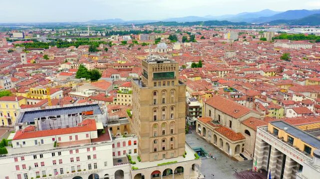 Brescia, Italy. Palazzo delle Poste, the austere ochre and white post office tower dominating Piazza della Vittoria, Drone footage over the rationalist square and terracotta rooftops. Drone footage, 