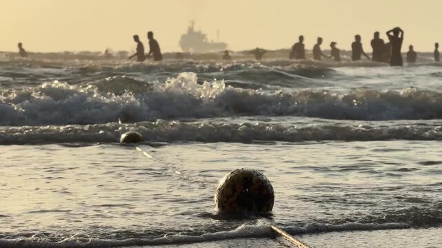 Safety Buoy Rope close up in Foamy Surf Waves at the beach with people in water. Swimming boundary rip current danger concept