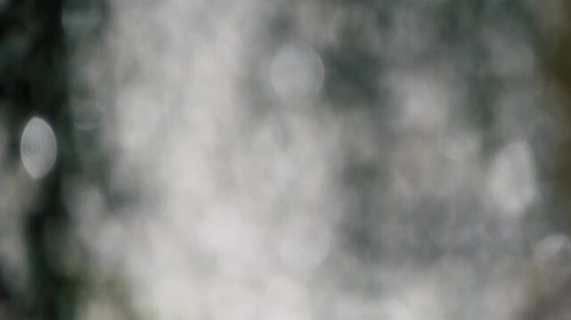 勢いよく飛沫を滴らせ落ちる噴水の水しぶき　キラキラ太陽の光を反射して輝く丸ボケ　夏・日本の季節・夏休み・水遊びの風景　