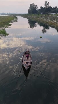 Serene river journey traditional wooden boat with fishermen calm water reflection sky clouds
