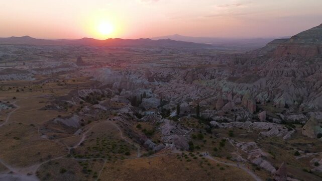Goreme, Nevsehir, Turkey. Red Valley at sunset, eroded volcanic tuff formations glowing in warm golden light, aerial panoramic view over the UNESCO landscape of Cappadocia. Aerial View