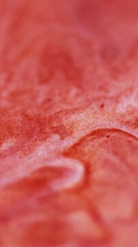 Vertical video. Acrylic fluid. Wet texture. Defocused orange color grain paint in water chemical flow spreading on abstract art background.