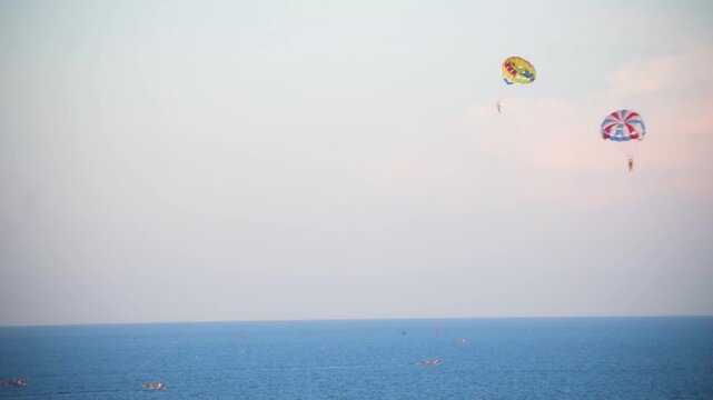 Colorful parasailing adventure over seawaves offers thrill and excitement, showcasing water sports, recreation and tourism activities popular in coastal destinations like Da Nang, Goa and Andaman.