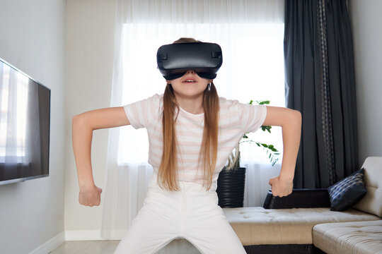 Teenage girl wearing virtual reality goggles headset and playing, vr box. technology, new generation, progress concept. Girl trying to touch objects in virtual reality.