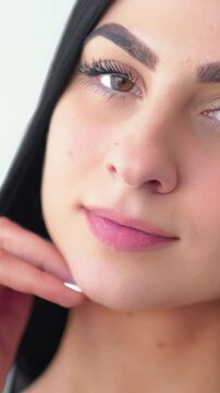 Vertical video. Healthy skin. Makeup routine. Woman caressing soft cheek. Confident lady enjoying modern cosmetic face treatment.