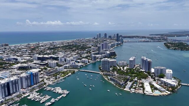 Aerial view of Miami skyline and waterfront islands over turquoise Biscayne Bay in sunny Florida, USA. g.