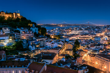 Naklejka premium A panoramic view over the rooftops of Alfama and the Tagus River, from the Miradouro da Graca viewpoint in Lisbon, Portugal