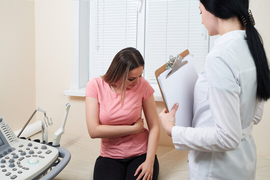 Patient showing paintful part of body. Gynecologist is going to ultrasound scan in modern clinic