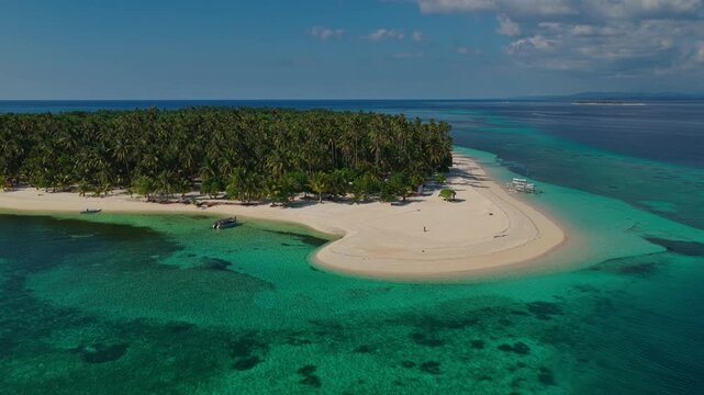 Wide angle aerial tracking orbit of Tangkahan Island from a distance moving left to right, Balabac, Philippines. Panoramic drone shot reveals entire tropical reef ecosystem and hook sandbar.