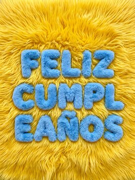 Feliz Cumpleanos Spanish Text Embossed On Fluffy Bright Yellow Fur Fabric Surface