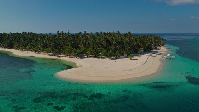 Low altitude aerial drone flight flying forward toward Tangkahan Island, Balabac, Philippines. Close-up sea level tracking shot approaching tropical hook sandbar and reef.