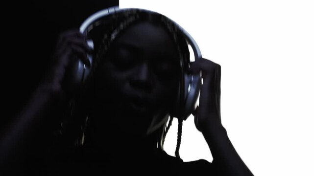 Music energy. Fun melody. Silhouette of joyful woman in headphones dancing listening favorite playlist isolated on white copy space.