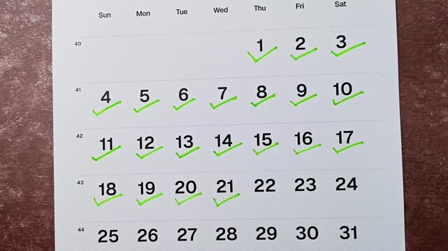 Hand putting green checkmark on calendar date 21. Goal achievement, success and task completion concept