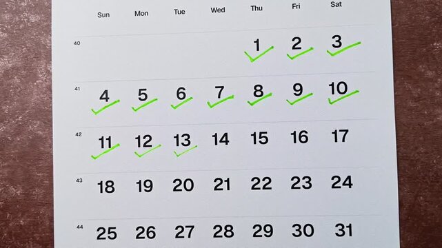 Hand putting green checkmark on calendar date 13. Goal achievement, success and task completion concept