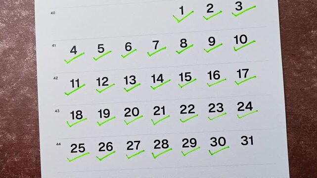 Hand putting green checkmark on calendar date 30. Goal achievement, success and task completion concept