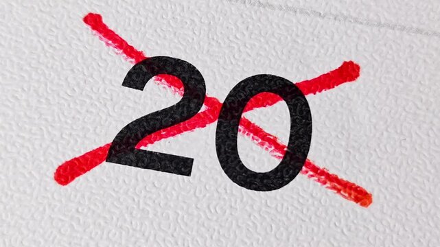Crossing out number 20 on calendar with red marker. Concept of cancellation or completion